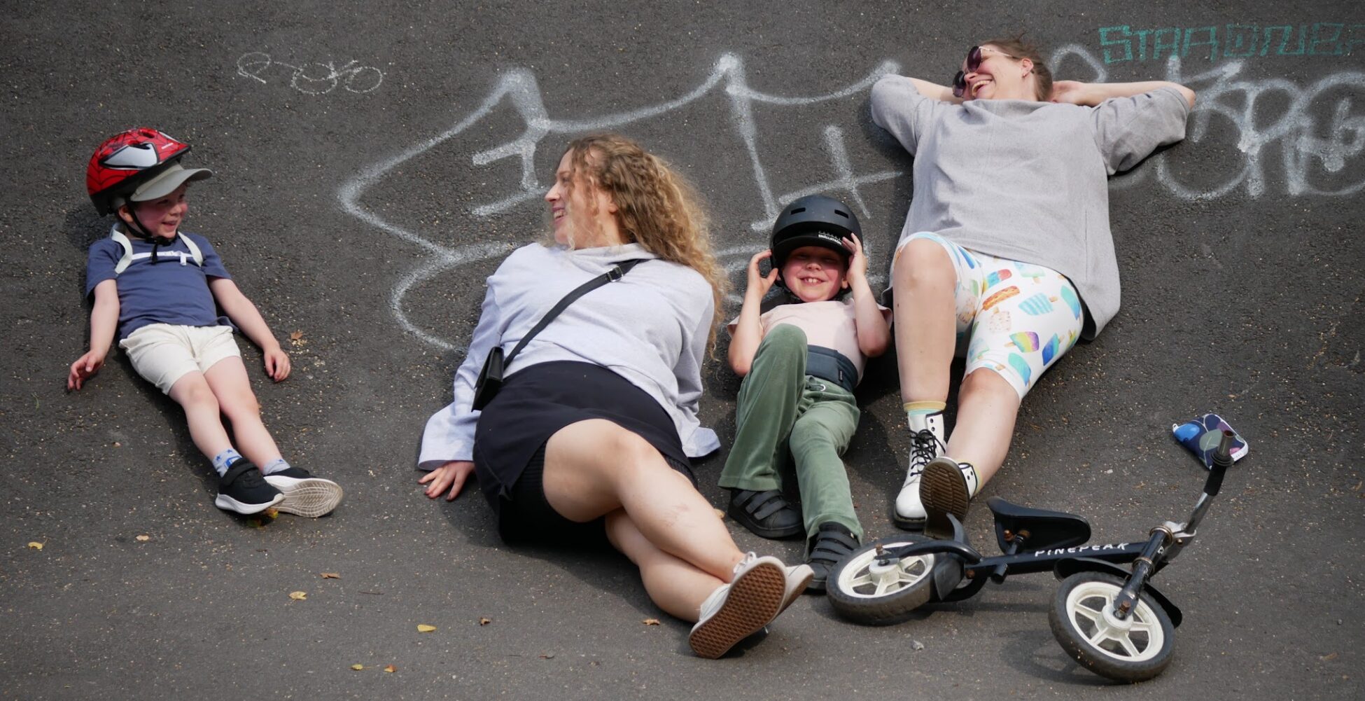 Kuvassa on lapsia ja aikuisia temppuradalla makoilemassa. Päällä on myös Keikku-tuotteita